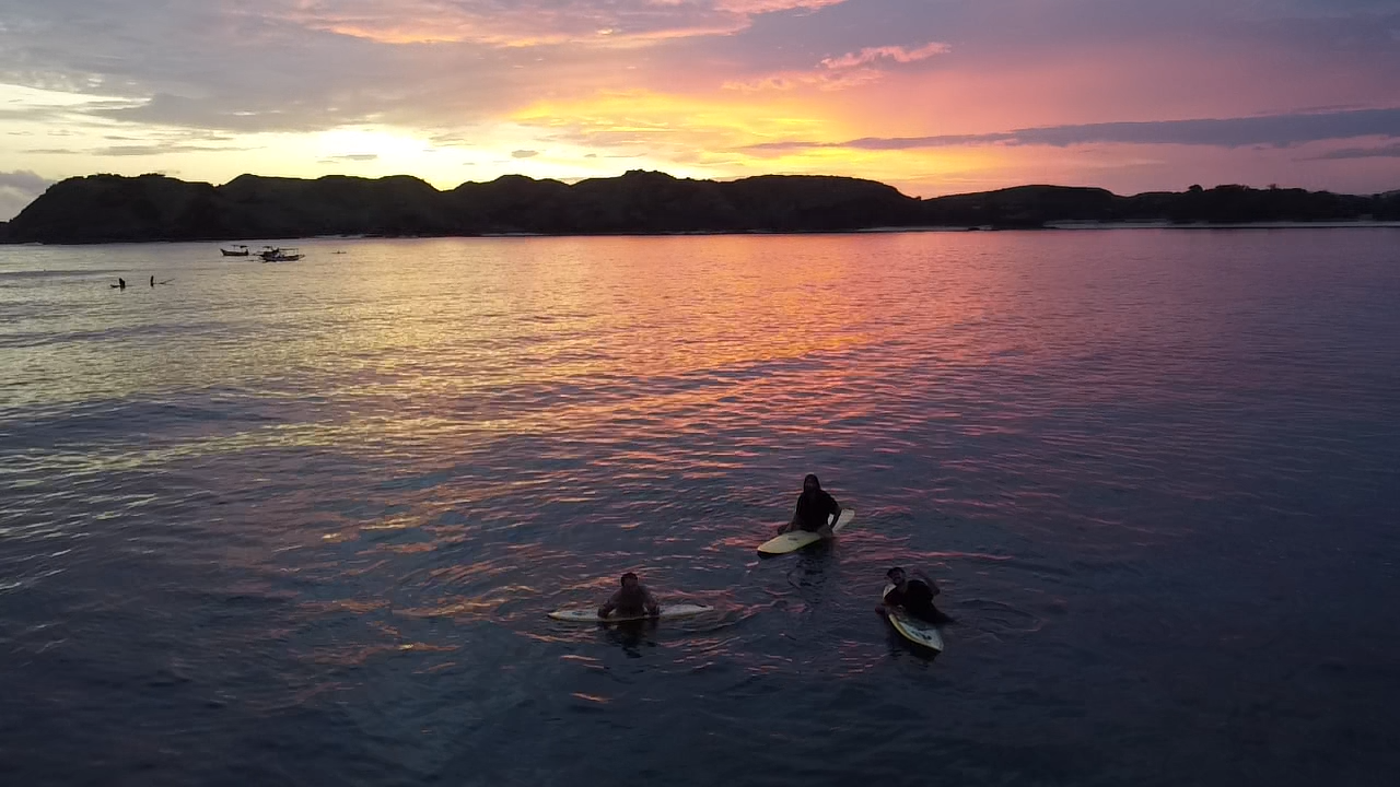 Surfers at sunset in Lombok
